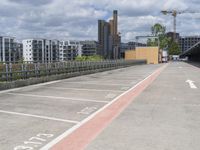 parking space at an apartment complex next to an overpass on a sunny day with city buildings