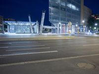 two people in the middle of the street crossing with some street lights on at night