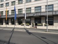 a bus is on the street next to many flags in front of a building on the road