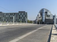 an empty street next to a building on the left and an office on the right