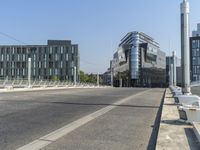 an empty street next to a building on the left and an office on the right