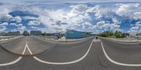 the reflection of a road in a fish eye lens, with several buildings in the background