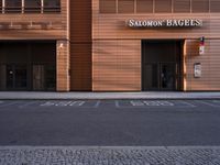 a building with four windows next to a street in front of it at dusk with light reflecting off the window