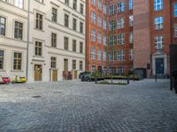 an empty parking lot with plants in the ground and on the side of the building, there is an enclosed area and windows