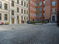 an empty parking lot with plants in the ground and on the side of the building, there is an enclosed area and windows