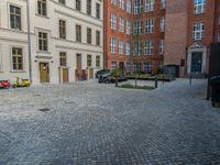 an empty parking lot with plants in the ground and on the side of the building, there is an enclosed area and windows