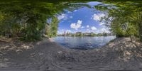 a fish eye view of a small pond on the shore of a lake with no waves