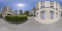 this is a 360 view of a building near the park in front of it, with bushes around and building