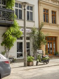 an older street with motorcycles and planters in the foreground, outside, of a building