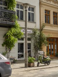 an older street with motorcycles and planters in the foreground, outside, of a building