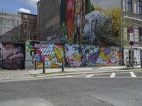 the street in front of the graffiti covered building is empty and empty, but has two rows