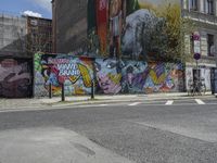 the street in front of the graffiti covered building is empty and empty, but has two rows