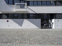 an architectural photo of a building with windows and door openings that has red circular buttons