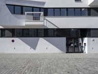 an architectural photo of a building with windows and door openings that has red circular buttons