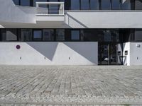 an architectural photo of a building with windows and door openings that has red circular buttons