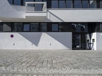 an architectural photo of a building with windows and door openings that has red circular buttons