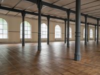 large floor with columns, windows and wood floors in an old building that has no walls