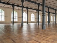 large floor with columns, windows and wood floors in an old building that has no walls