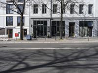 a bike sits in front of a building near a bike rack and a sidewalk, on which are no cars