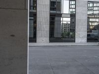 a person on a skateboard rides along the sidewalk next to a building with windows