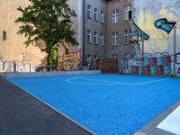 a basketball court in the middle of a street with graffitti on it and graffiti all over it