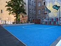 a basketball court in the middle of a street with graffitti on it and graffiti all over it