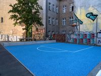 a basketball court in the middle of a street with graffitti on it and graffiti all over it