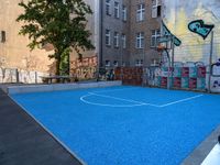 a basketball court in the middle of a street with graffitti on it and graffiti all over it