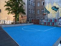 a basketball court in the middle of a street with graffitti on it and graffiti all over it