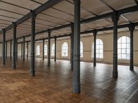 a large empty room with windows and wooden floors with columns that are leaning down to the left