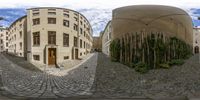 a street view with a circular shaped building in the middle of it and a tree in the background