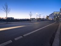 a couple cars driving down a city street at dusk time in europe - a long exposure lensing, with no people in the shot