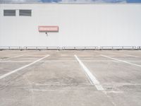 an empty parking lot near some very large buildings as if they were the only space to be left