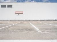 an empty parking lot near some very large buildings as if they were the only space to be left