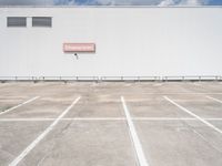 an empty parking lot near some very large buildings as if they were the only space to be left