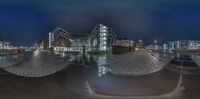 multiple pictures of a circular building at night in urban city setting with no one else