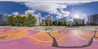 a mirror view of a skateboard park with colorful pavement and buildings in the background