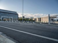 the empty street has white markers on it, and a building in the background with some windows