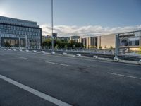 the empty street has white markers on it, and a building in the background with some windows