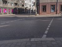 a city street with several people walking on it and buildings in the background, there's a traffic light on one side, a man is walking down one side,