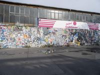 the city side of a building covered in grafitti paper and a large american flag