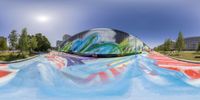 a man is riding on a skateboard down a slope covered in colorful paint,