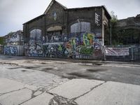 a building with lots of graffiti painted on it, along with graffiti written all over the side