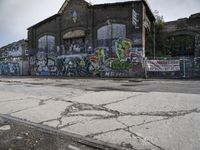 a building with lots of graffiti painted on it, along with graffiti written all over the side