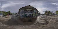 a fisheye lens image taken on a street corner of an old building with graffiti