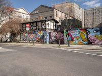 an empty street with colorful graffiti on the wall in the city setting, on a clear day