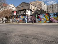 an empty street with colorful graffiti on the wall in the city setting, on a clear day