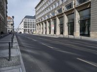 empty street with parking meters on both sides and stone walkways along the side of the road