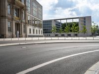 a street scene, with a fence along the road and building in the background in this image,