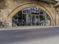 a street with two buildings and graffiti on the walls with old doors and windows that are leaning against each other